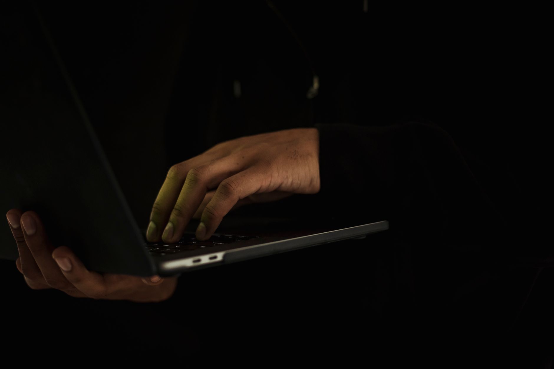 Person typing their name into a search engine on a laptop while looking concerned about their personal information.