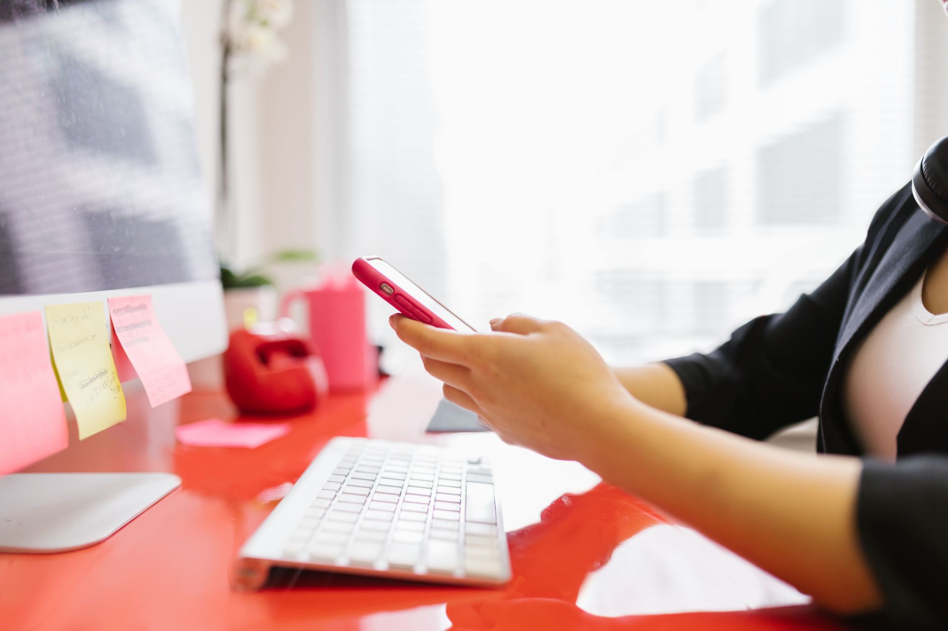 A person holds a smartphone and deletes unwanted email messages.